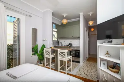 a kitchen with green cabinets and a bed in a room at Artemonos Loft Acropolis View in Athens