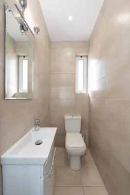 a white bathroom with a toilet and a sink at Seaside Breeze - 2 Bdrm Apartment in Palaio Faliro - Sea View in Athens