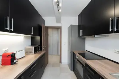 a kitchen with black cabinets and wooden counter tops at Seaside Breeze - 2 Bdrm Apartment in Palaio Faliro - Sea View in Athens