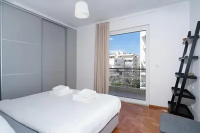 a bedroom with a white bed and a large window at Seaside Breeze - 2 Bdrm Apartment in Palaio Faliro - Sea View in Athens
