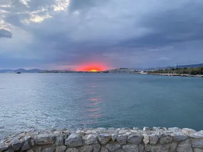 a sunset over a large body of water at Seaside Breeze - 2 Bdrm Apartment in Palaio Faliro - Sea View in Athens