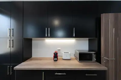 a kitchen with black cabinets and a microwave at Seaside Breeze - 2 Bdrm Apartment in Palaio Faliro - Sea View in Athens