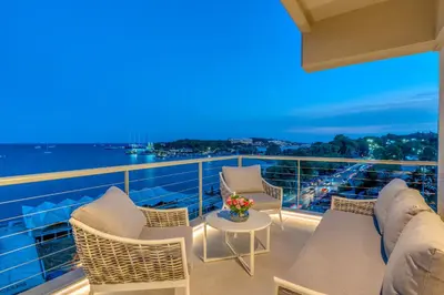 a balcony with chairs and a table on a ship at Vouliagmeni - Apollonos Street in Athens