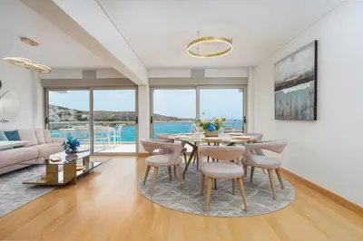 a dining room with a table and chairs and a couch at Vouliagmeni - Apollonos Street in Athens