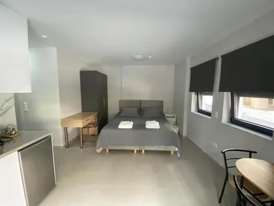 a bedroom with a bed and a table and chairs at FEELS LIKE HOME in Athens