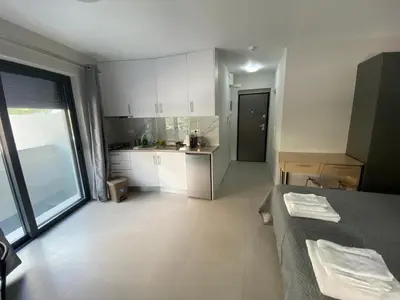 a kitchen with white cabinets and a table in a room at FEELS LIKE HOME in Athens