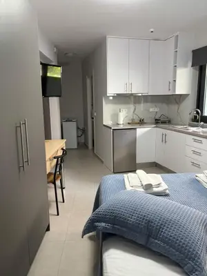 a kitchen with white cabinets and a blue bed in a room at FEELS LIKE HOME in Athens
