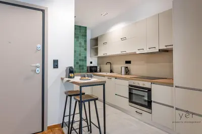 a kitchen with white cabinets and a bar with stools at Comfort Oasis: Work-Friendly Space w/Fiber Net in Athens