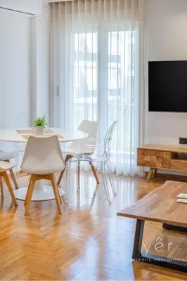 a living room with a table and a flat screen tv at Comfort Oasis: Work-Friendly Space w/Fiber Net in Athens