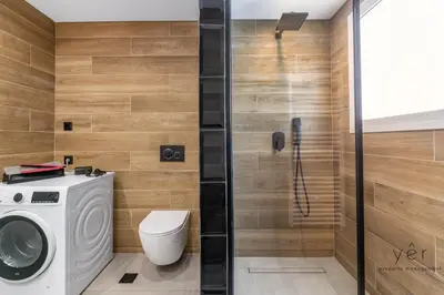 a bathroom with a washing machine and a shower at Comfort Oasis: Work-Friendly Space w/Fiber Net in Athens