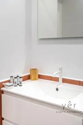 a bathroom counter with a sink and a mirror at Shell-Charm w/Sea View & Parking in Piraeus