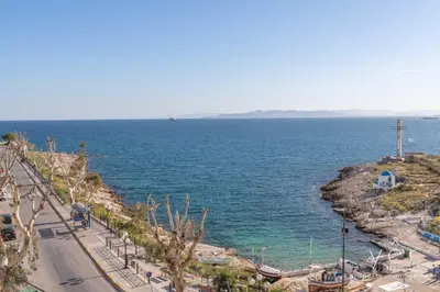 a view of the ocean from a hill with a cross at Shell-Charm w/Sea View & Parking in Piraeus