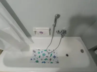 a white bath tub with a shower in a bathroom at 3-Generations Athenian home in Athens