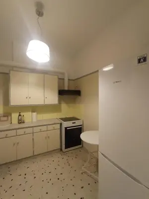 a kitchen with white cabinets and a white refrigerator at 3-Generations Athenian home in Athens