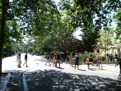 a group of people walking down a street at 3-Generations Athenian home in Athens