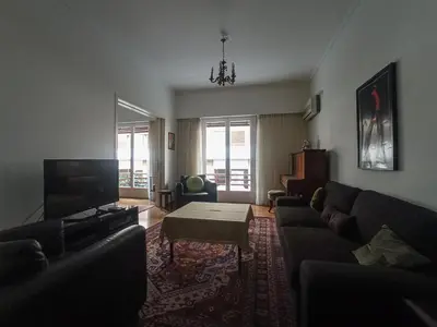 a living room with a couch and a table at 3-Generations Athenian home in Athens