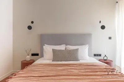 a bedroom with a large bed with a gray headboard at Luxury Flat w/2Bath - Private Parking @Pasalimani in Piraeus