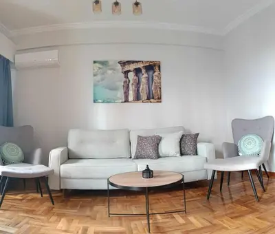 a living room with a couch and two chairs at Caryatids Luxury Apartment in Athens