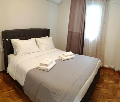 a bedroom with a bed with two towels on it at Caryatids Luxury Apartment in Athens