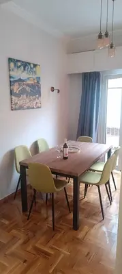 a dining room table and chairs in a room at Caryatids Luxury Apartment in Athens