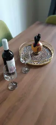 a glass plate with a bottle of wine on a table at Caryatids Luxury Apartment in Athens
