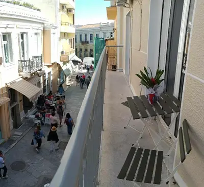 a balcony of a building with people walking down a street at Caryatids Luxury Apartment in Athens