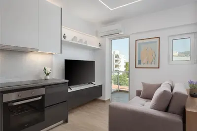a living room with a couch and a television at Athenian Riviera Seaside Suite in Athens
