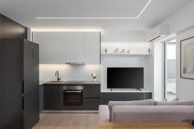 a kitchen and living room with a couch and a tv at Athenian Riviera Seaside Suite in Athens
