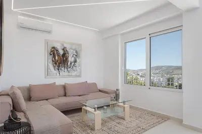 a living room with a couch and a glass table at Athenian Riviera Penthouse Apartment in Varkiza
