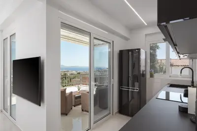 a kitchen with sliding glass doors with a view at Athenian Riviera Penthouse Apartment in Varkiza