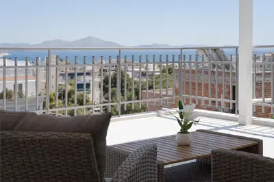 a patio with a table and chairs on a balcony at Athenian Riviera Penthouse Apartment in Varkiza