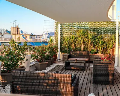 a patio with furniture and plants on a balcony at Bachelor Penthouse with Roof Garden access, 15 m walk to Acropolis in Athens