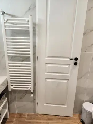 a bathroom with a white door in a room at Bachelor Penthouse with Roof Garden access, 15 m walk to Acropolis in Athens