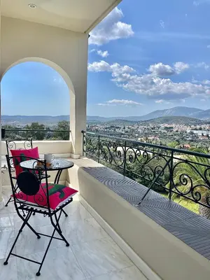 a balcony with a table and chairs and a view at Villa Zen Kyriakos Magnificent Vibes in Paianía
