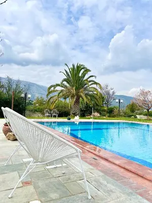 a white chair sitting next to a swimming pool at Villa Zen Kyriakos Magnificent Vibes in Paianía