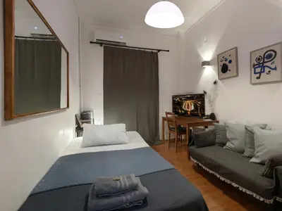 a small bedroom with a bed and a couch at Central Apartment in Pangrati - Opp Pangrati Grove in Athens