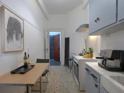 a kitchen with white cabinets and a table with wine bottles at Central Apartment in Pangrati - Opp Pangrati Grove in Athens