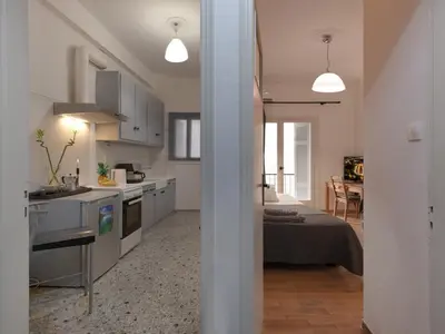 a kitchen and living room with a bed and a table at Central Apartment in Pangrati - Opp Pangrati Grove in Athens