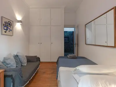 a bedroom with a bed and a couch and a mirror at Central Apartment in Pangrati - Opp Pangrati Grove in Athens