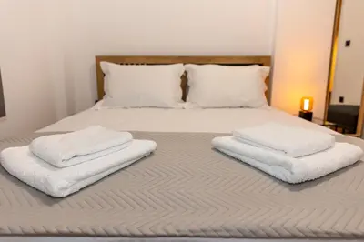 a bed with three towels on top of it at Where Dreams Attend Address! in Athens