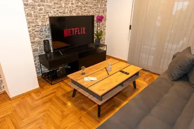 a living room with a couch and a tv at Where Dreams Attend Address! in Athens