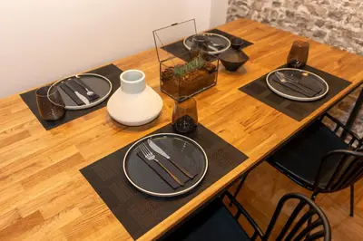 a wooden table with plates and utensils on it at Where Dreams Attend Address! in Athens
