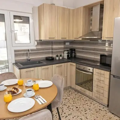 a kitchen with a wooden table with two plates on it at Cozy Apartment in Kallithea in Athens