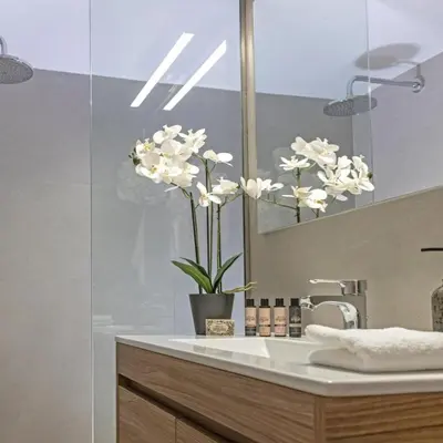 a bathroom with a sink with a vase of flowers at Cozy Apartment in Kallithea in Athens