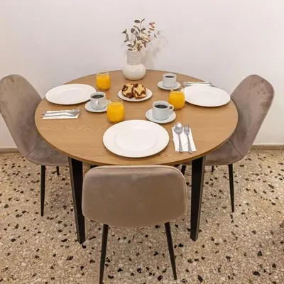 a wooden table with chairs and plates of food on it at Cozy Apartment in Kallithea in Athens
