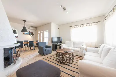 a living room with white furniture and a fireplace at Luxury Home with Jacuzzi and Spectacular Sea Views for 8 Guests in Athens