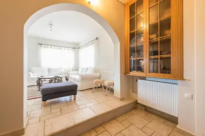 a living room with an archway and a table and chairs at Luxury Home with Jacuzzi and Spectacular Sea Views for 8 Guests in Athens