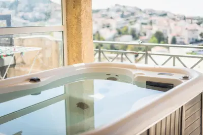 a bathtub in a balcony with a view of a city at Luxury Home with Jacuzzi and Spectacular Sea Views for 8 Guests in Athens
