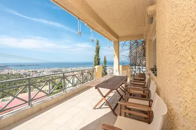 a balcony with a table and chairs and a view of the city at Luxury Home with Jacuzzi and Spectacular Sea Views for 8 Guests in Athens