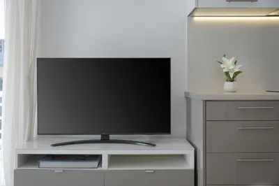 a flat screen tv sitting on a white entertainment center at Varkiza Seaside Apartment in Vari